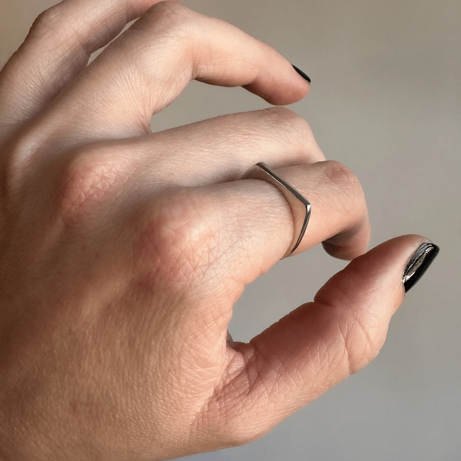 Side view of the sterling silver tapered ring worn on a hand.