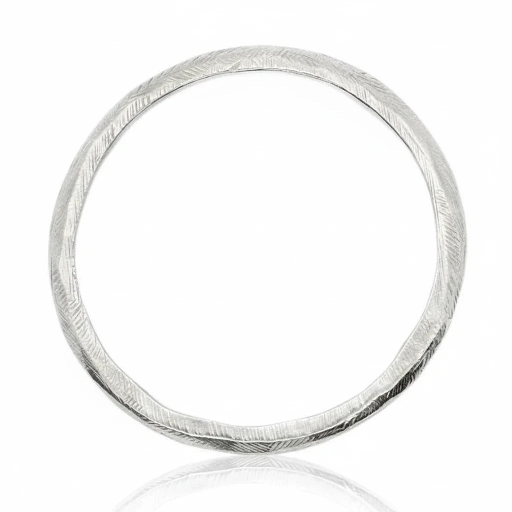 Silver Reyes Bangle Bracelet by Ladha Jewelry, handcrafted in sterling silver with a carved textured surface and sculptural circular design.