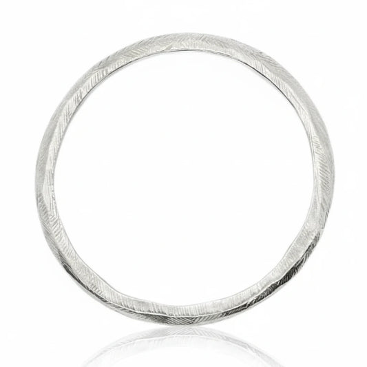 Silver Reyes Bangle Bracelet by Ladha Jewelry, handcrafted in sterling silver with a carved textured surface and sculptural circular design.