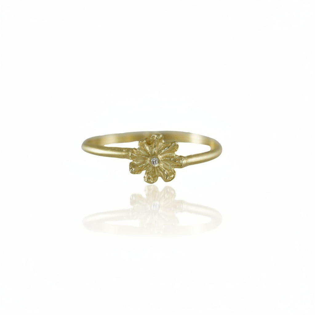 Front view of the Small Efflorescent Stacking Ring by Alexis Pavlantos, featuring a hand-carved floral design in solid 14k yellow gold with a flush-set 1mm natural diamond at its center.