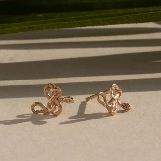 Handcrafted 14k yellow gold Snake Guardian Stud Earrings displayed together, showcasing their intricate snake silhouettes.