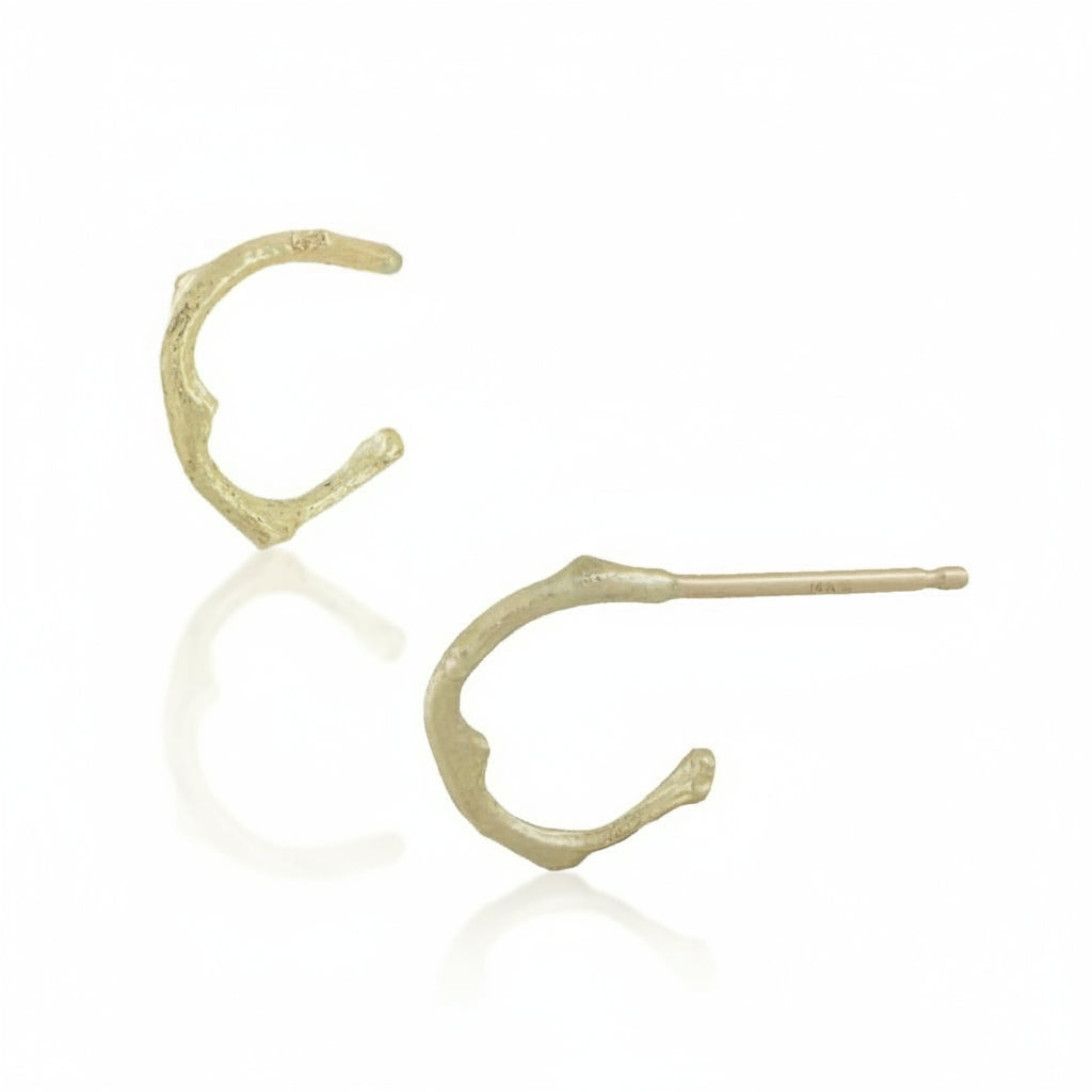 Side view of 14k yellow gold Sprig Hug Hoop Earrings showing their curved twig-inspired design and friction post closures.