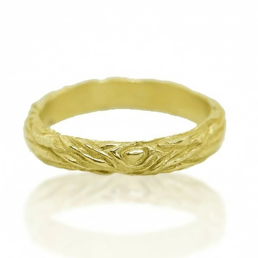 Front view of the Sprig Ring by Alexis Pavlantos, featuring a delicate 14k yellow gold band with hand-carved twig and wood-grain textures.