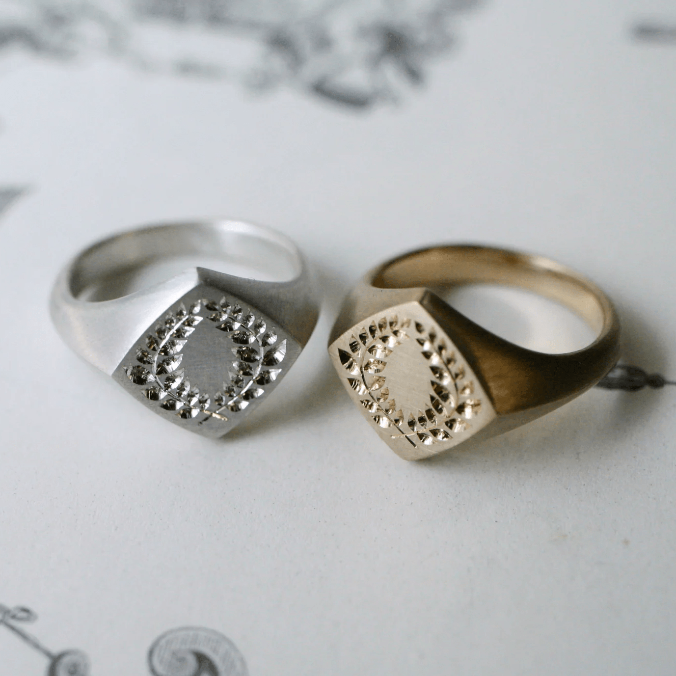 Sterling silver and 14k gold laurel square signet rings side by side – engraved matching signet rings