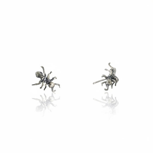Handcrafted sterling silver Ant Stud Earrings by Alexis Pavlantos featuring detailed sculptural ant designs with delicate legs and segmented bodies, photographed as a pair on a white background.