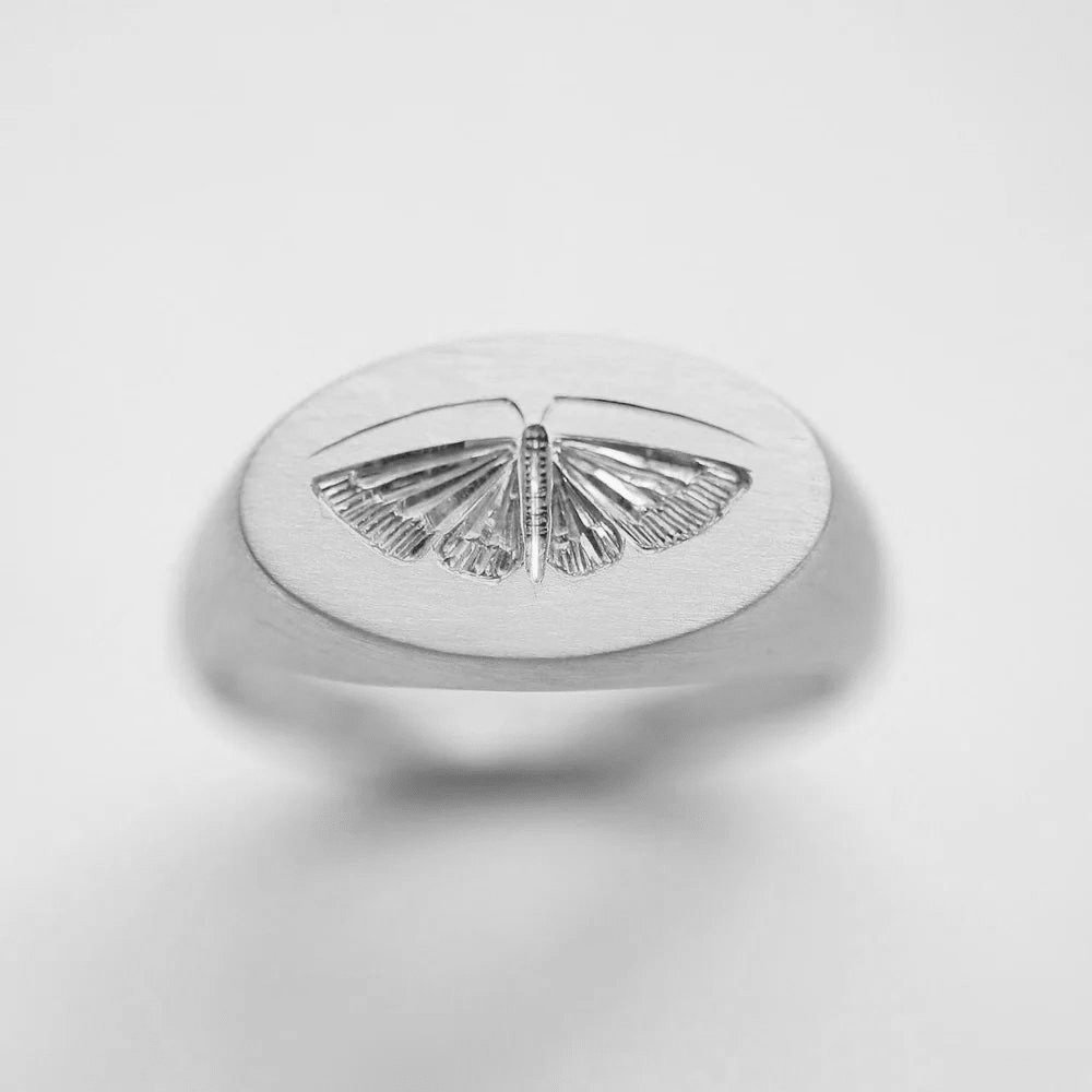 Sterling silver house moth ring shown at an angled view on a light background.