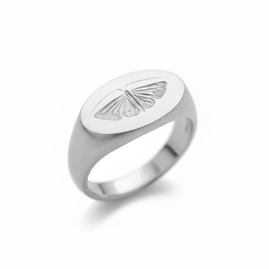 Front view of a sterling silver house moth ring with a hand-engraved moth design on a white background.