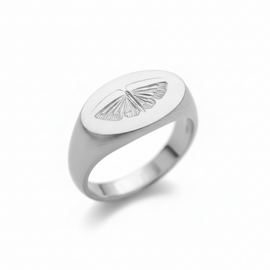 Front view of a sterling silver house moth ring with a hand-engraved moth design on a white background.