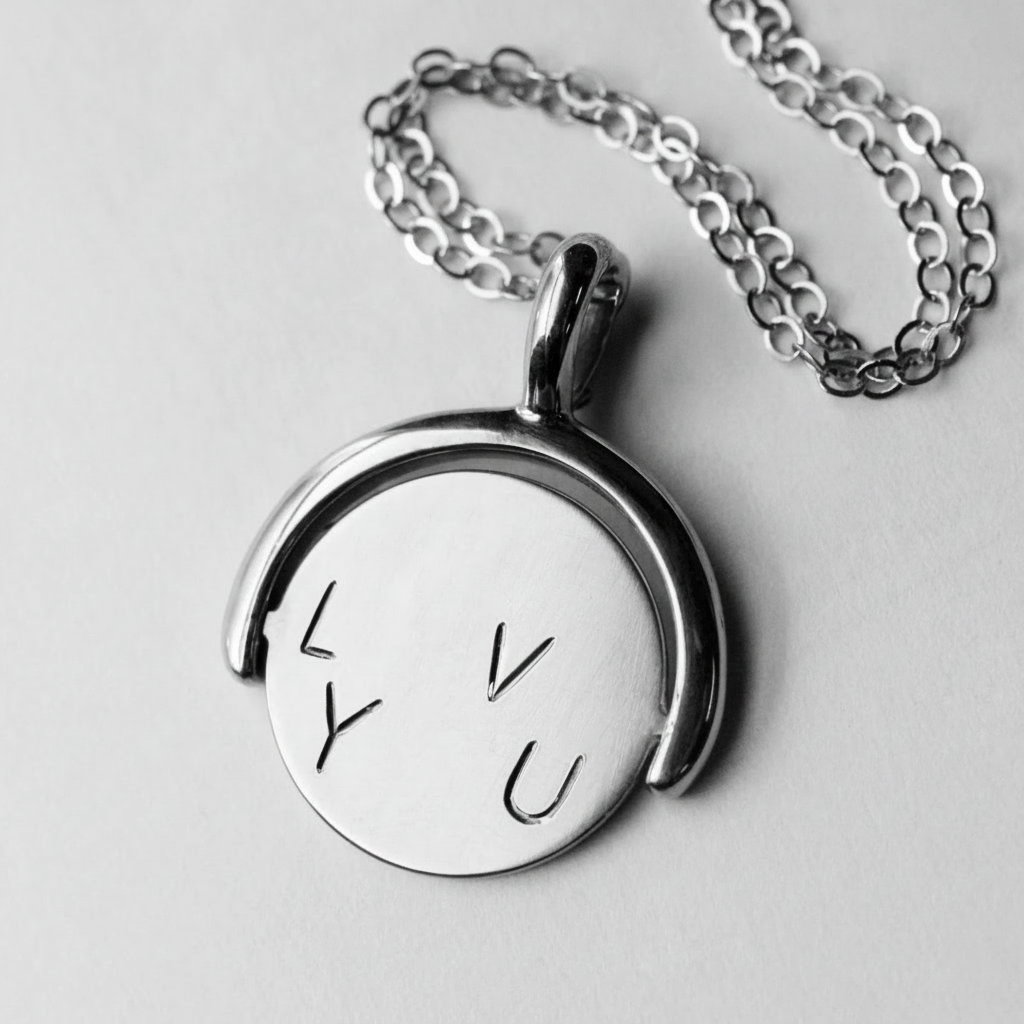 Sterling silver love-you spinner pendant with engraved letters on both sides.
