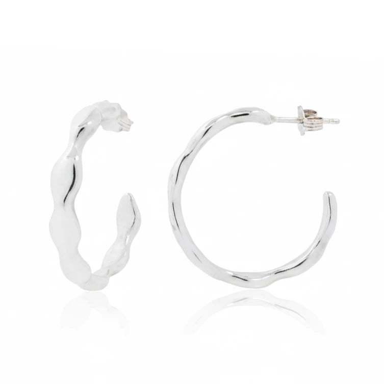 Sterling silver Ripple Hoop Earrings by Adeline Jewelry featuring sculptural wavy curves and a polished finish, shown from front and side.
