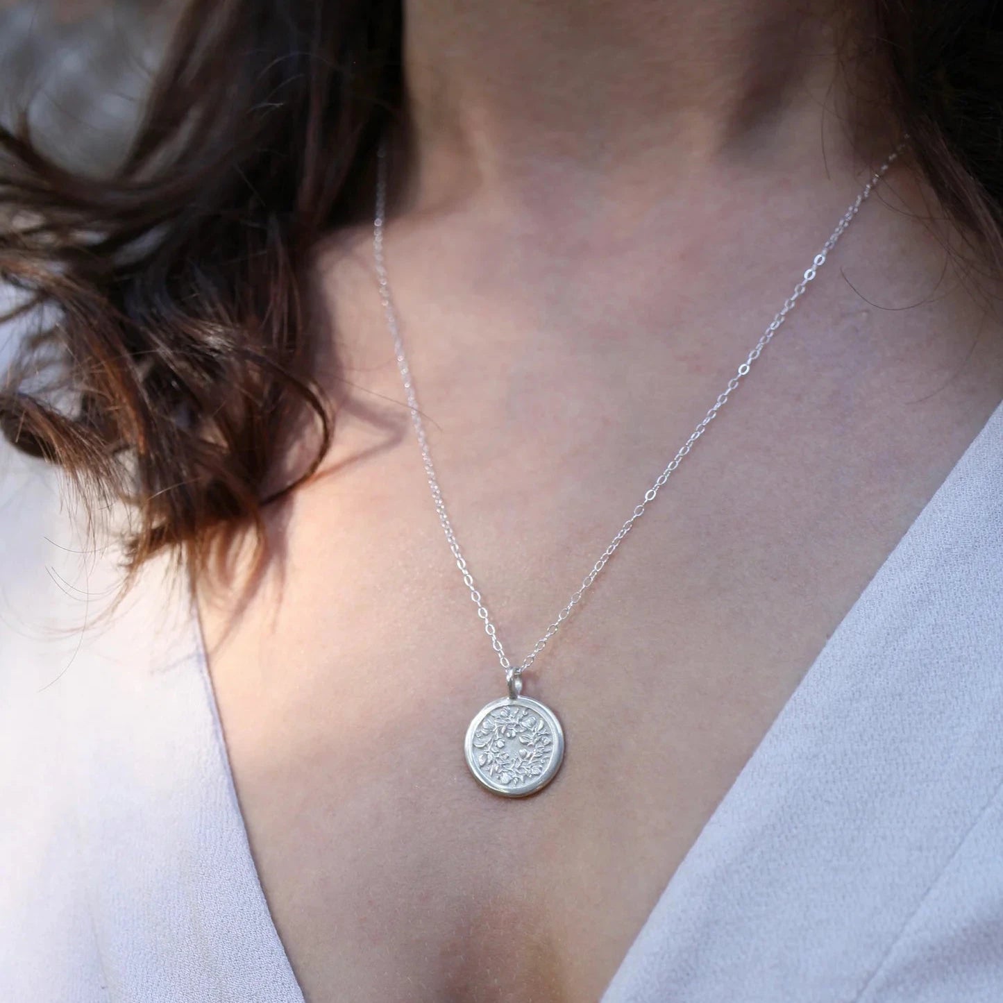 Sterling silver Sweet Pea engraved pendant worn on chest – floral medallion necklace.