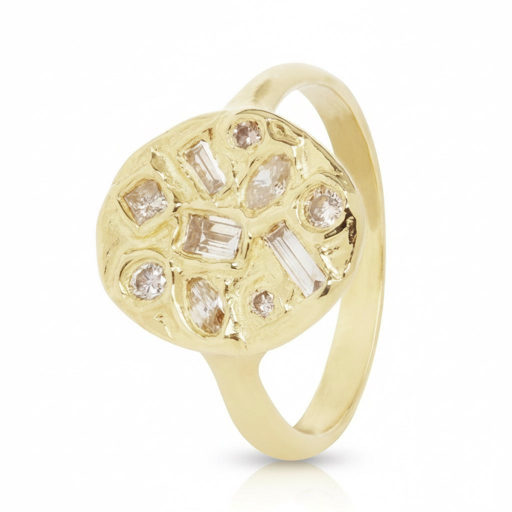 Angled view of the handcrafted Symplegma Diamond Signet Ring in solid 18k yellow gold, showcasing its textured oval face and cluster of differently shaped rose-cut diamonds.