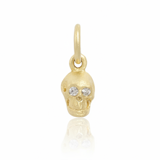 Crypta Skull Pendant by Gina Pinzari of Talking Tree, handcrafted in solid 14k yellow gold with two sparkling round diamond eyes and a sculpted miniature skull design.