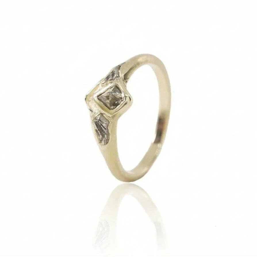 Angled view of the Tava Ring showing its natural kite-shaped diamond, textured 14k gold setting, and organic geological details.