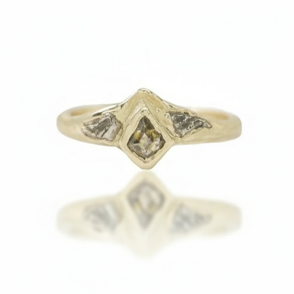 Close-up of the Tava Ring featuring a kite-shaped natural diamond surrounded by hand-carved, rock-inspired details in 14k yellow gold.