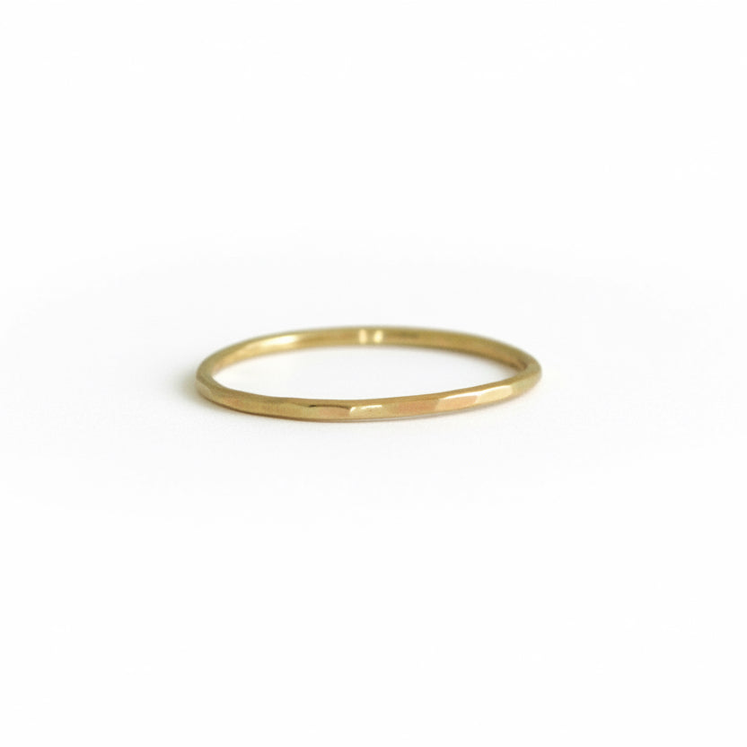 Front view of Teko Gallery's 14k solid yellow gold stacking ring with a delicate hand-hammered texture, photographed on a white background.