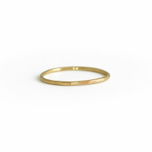 Front view of Teko Gallery's 14k solid yellow gold stacking ring with a delicate hand-hammered texture, photographed on a white background.