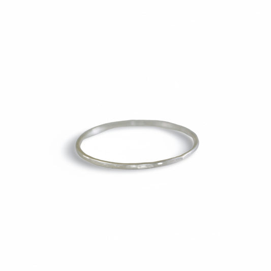 Front view of Teko Gallery's slim sterling silver stacking ring with a hand-hammered surface and polished silver finish against a white background.