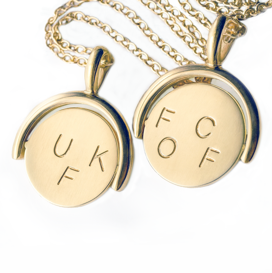 Pair of 14k gold thaumatrope pendants displayed together, one showing the letters U, K, F and the other F, C, O, F, both shown with matching gold cable chains.