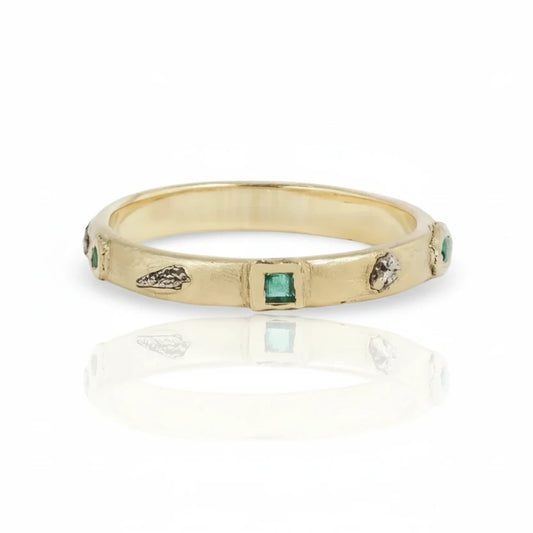 14k yellow gold 3/4 Meta Ring by Alexis Pavlantos featuring a green gemstone center and mixed-metal accents with small gemstones set along a sculptural band.