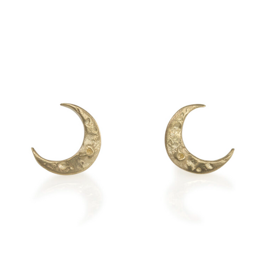Pair of Tiny Crescent Moon Stud Earrings by Luana Coonen, handcrafted in 14k yellow gold with delicate carved crater textures.