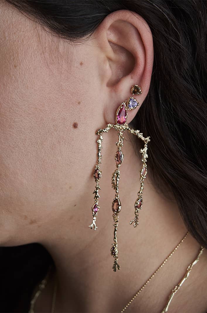 Close-up of the Tourmaline Coral Chandelier Earrings worn on a model, showcasing their cascading tourmaline gemstones, intricate 14k yellow gold craftsmanship, and statement length.