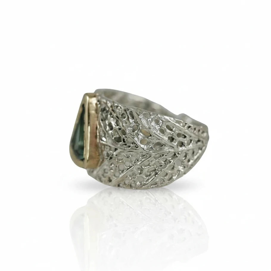 Side view of the Litter-fall Ring V, showcasing its hand-carved sterling silver band, organic leaf-inspired texture, and triangular green tourmaline set in 14k yellow gold.
