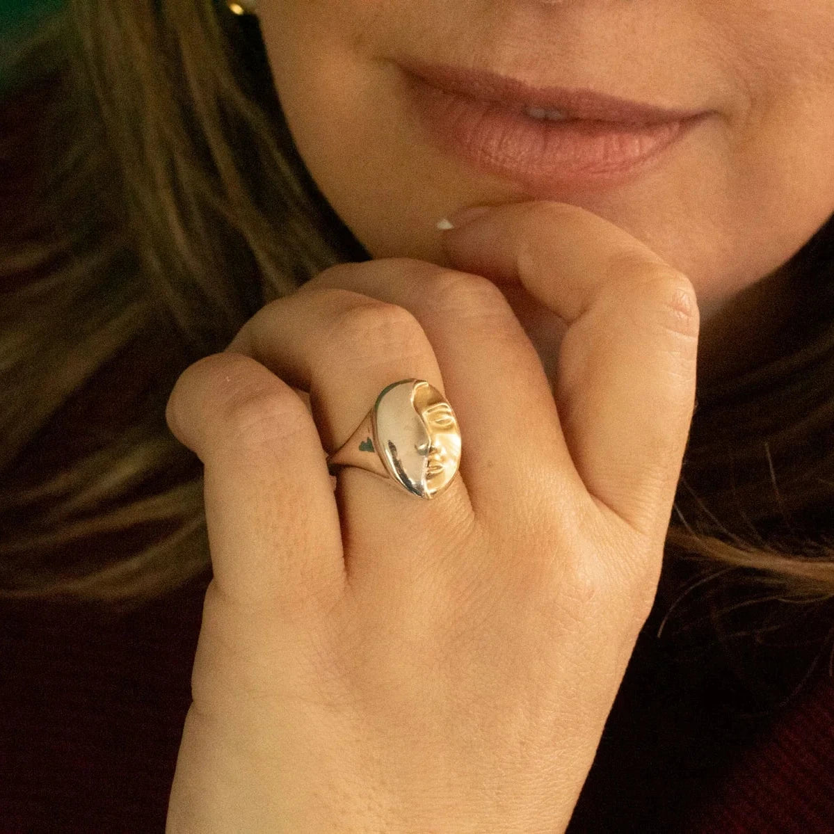 Close-up of the Truth Mixed Metal Ring worn on a finger, showing its dimensional 14k gold face and polished sterling silver.