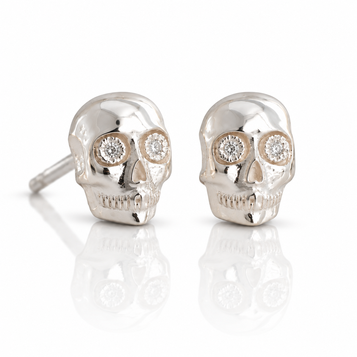 Underworld Skull Stud Earrings by Michaela Farkasovska in sterling silver, featuring sculptural skull faces and tiny diamond eyes.