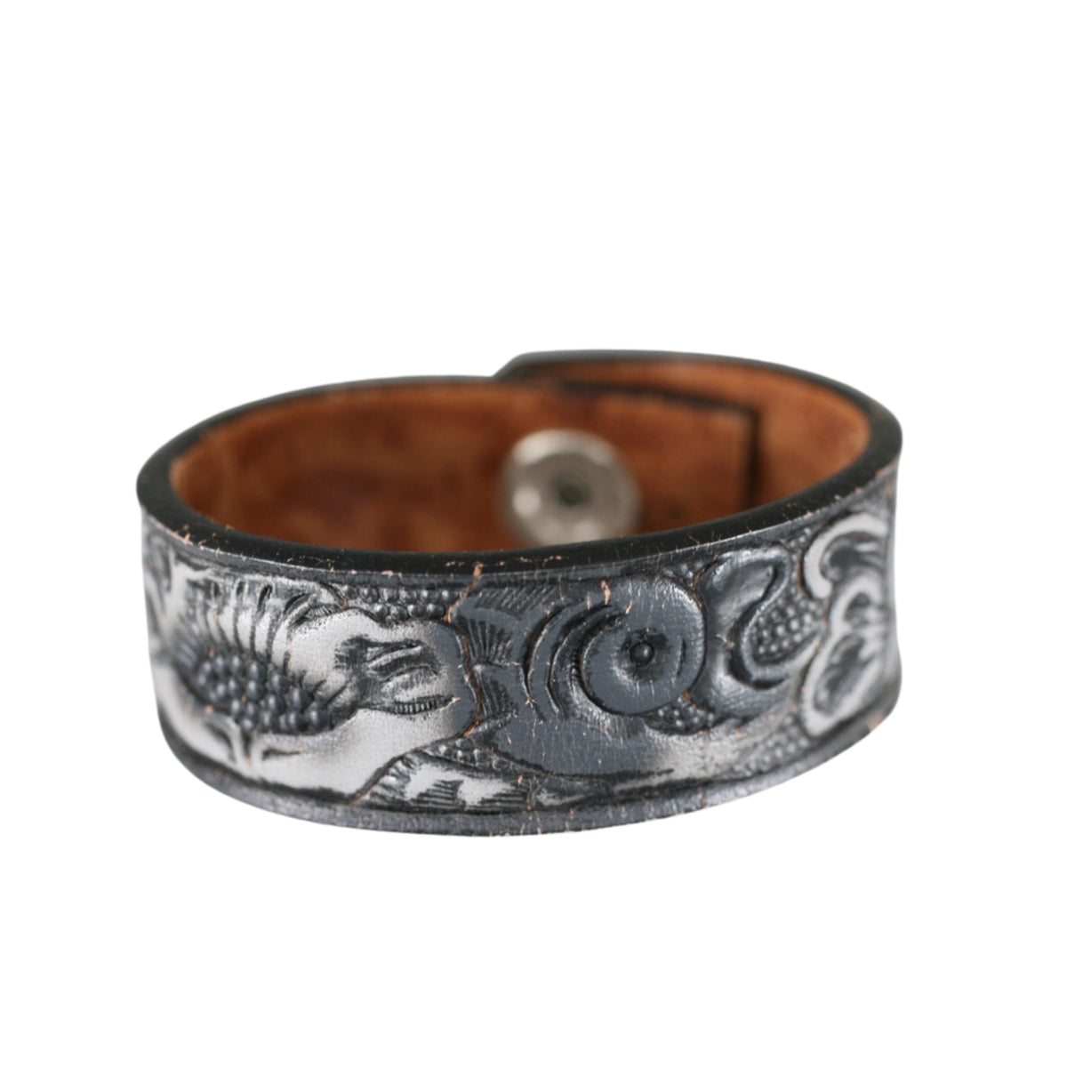Vintage dark leather cuff bracelet with silver-toned floral tooling and a distressed finish by Kelly Horrigan Handmade.