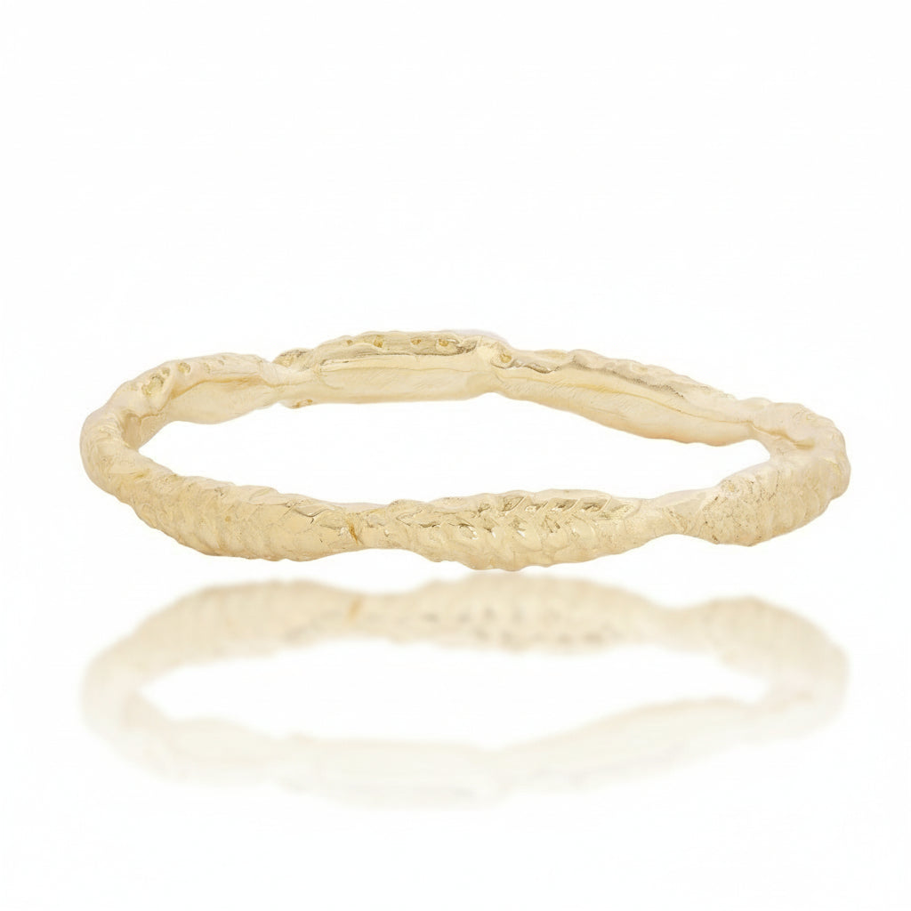 Front view of the Wheat Ring by Alexis Pavlantos, featuring a delicate hand-carved wheat motif in 14k yellow gold with an organic textured band inspired by nature.